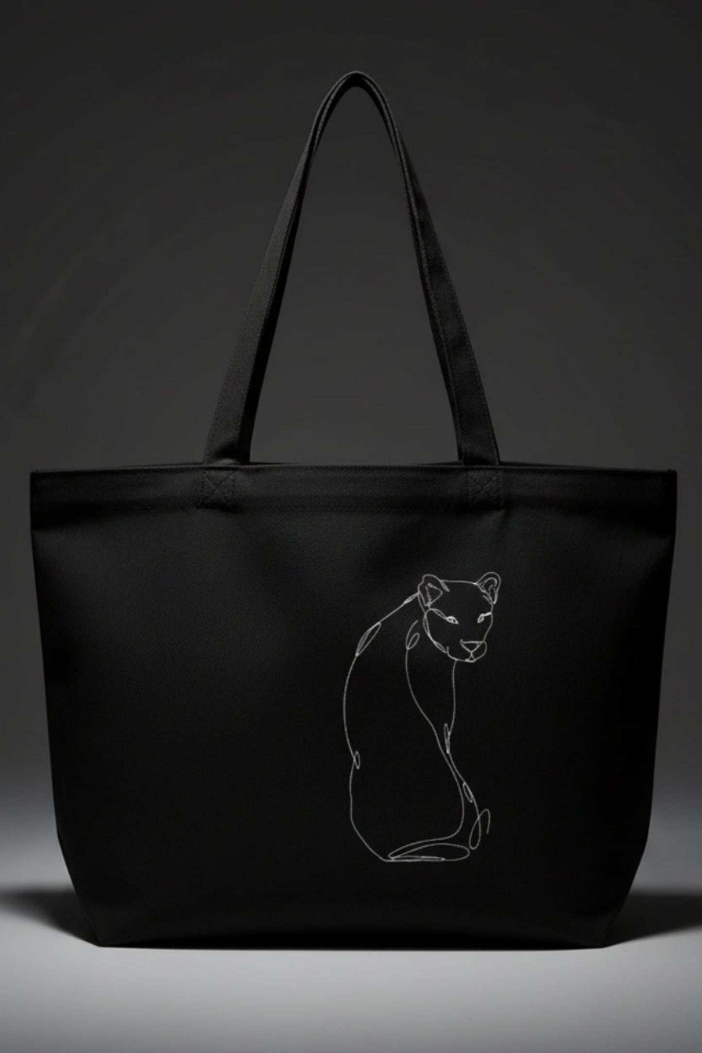 A black tote bag against a grey background