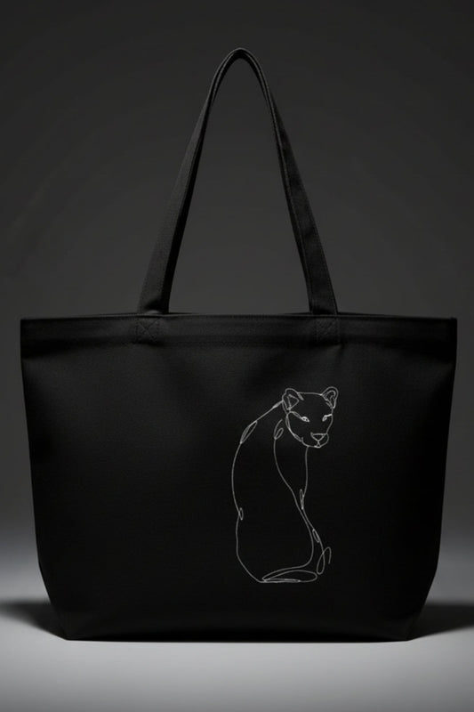 A black tote bag against a grey background