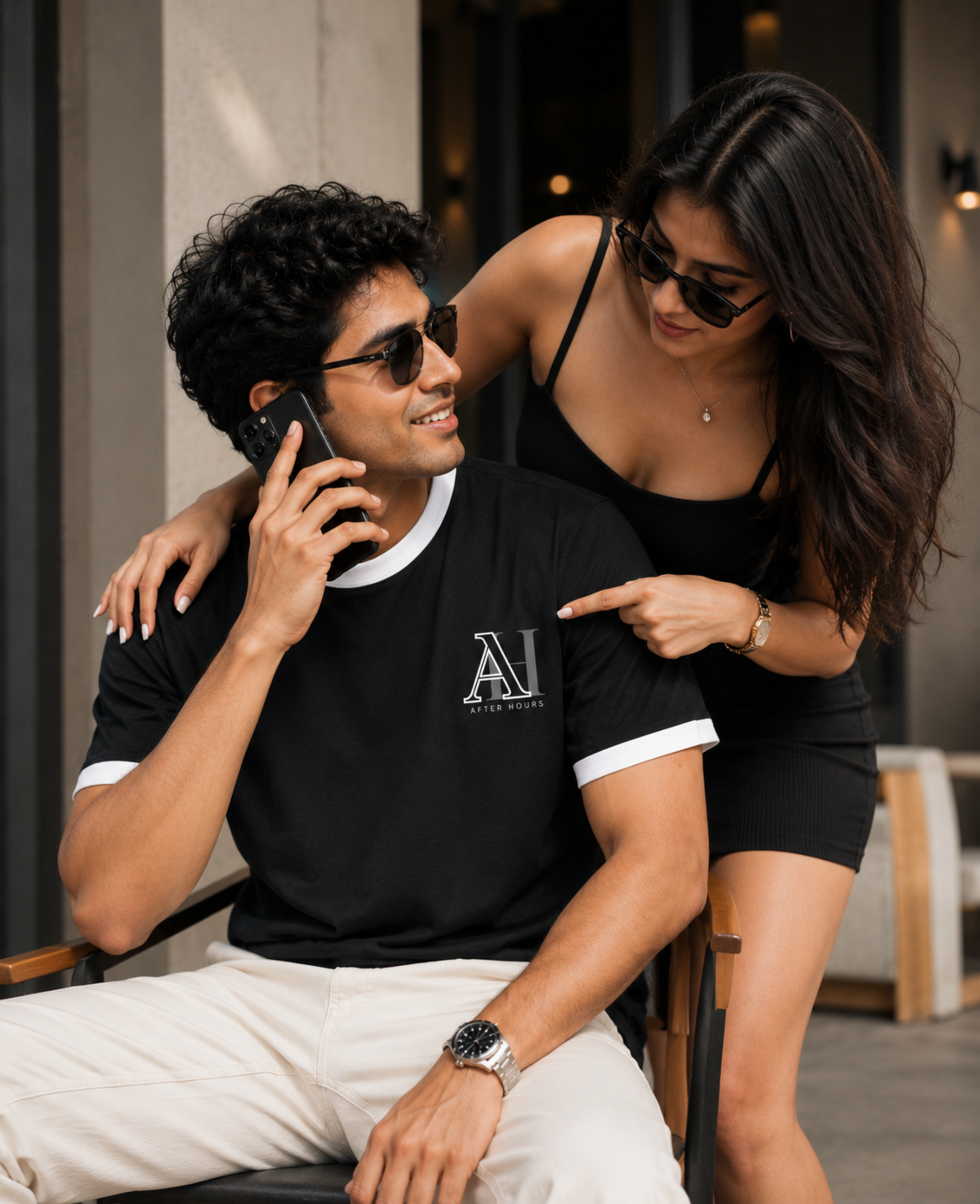 Man talking on a phone with a woman pointing at him, both wearing sunglasses.