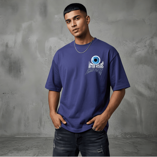 Man wearing a blue t-shirt with a logo against a gray textured wall