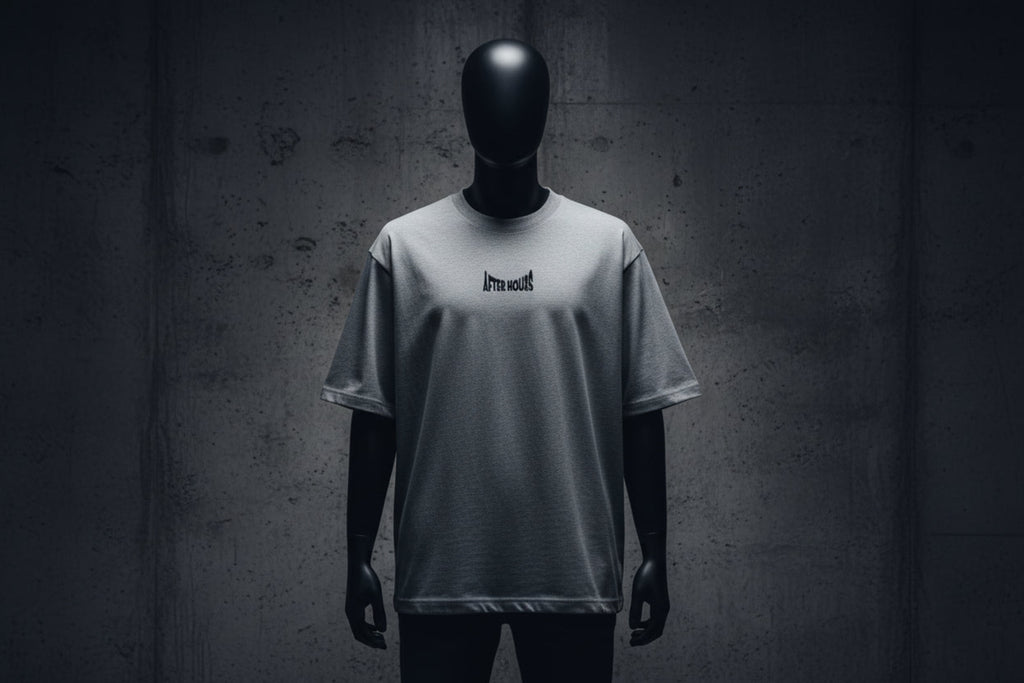 Grey t-shirt with a small black logo embroidered on a grey background