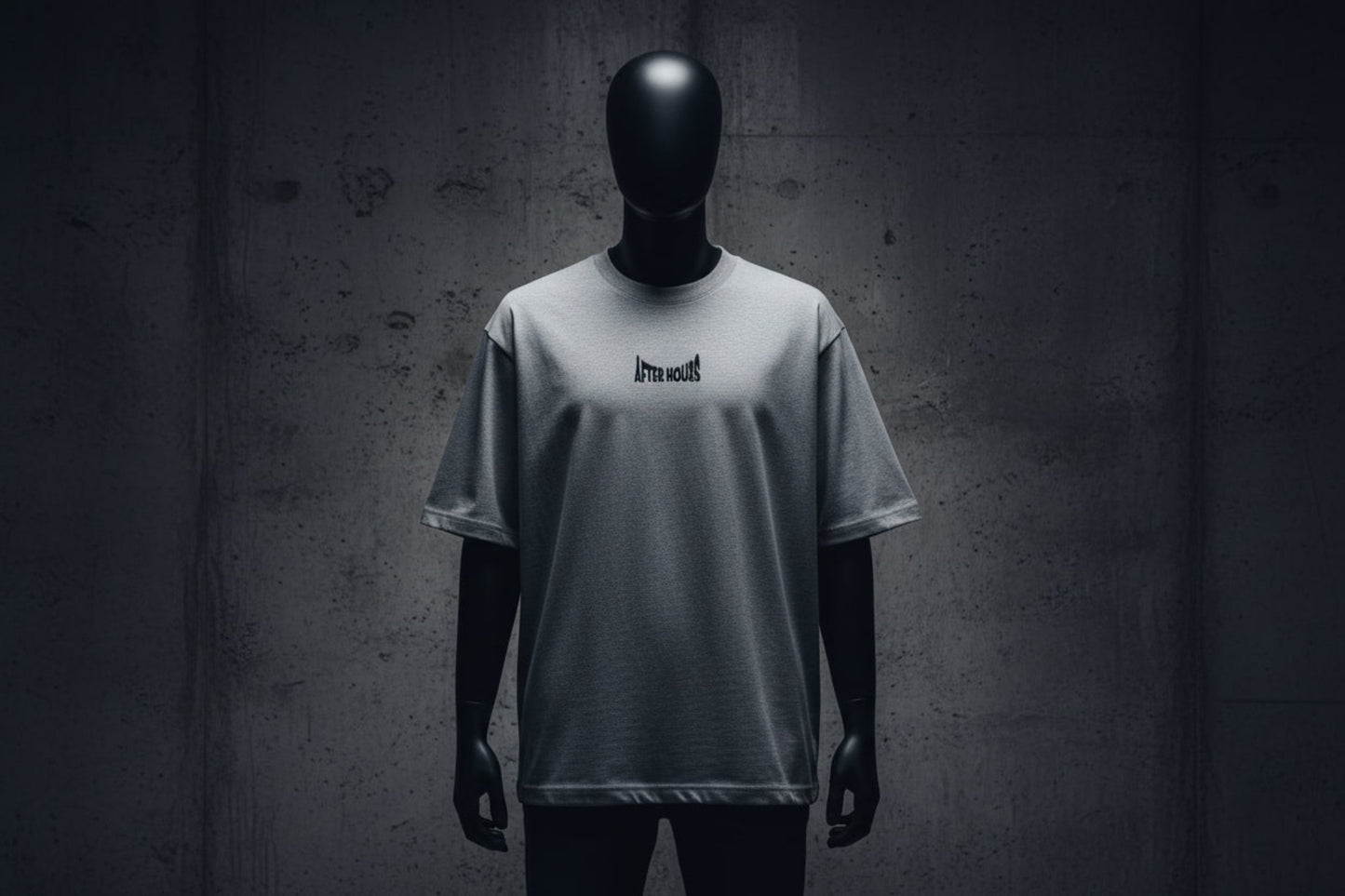 Grey t-shirt with a small black logo embroidered on a grey background