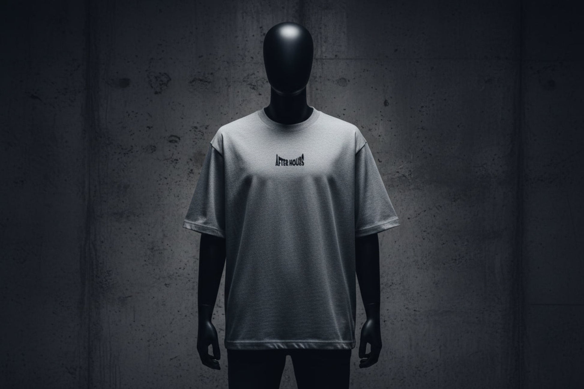 Grey t-shirt with a small black logo embroidered on a grey background