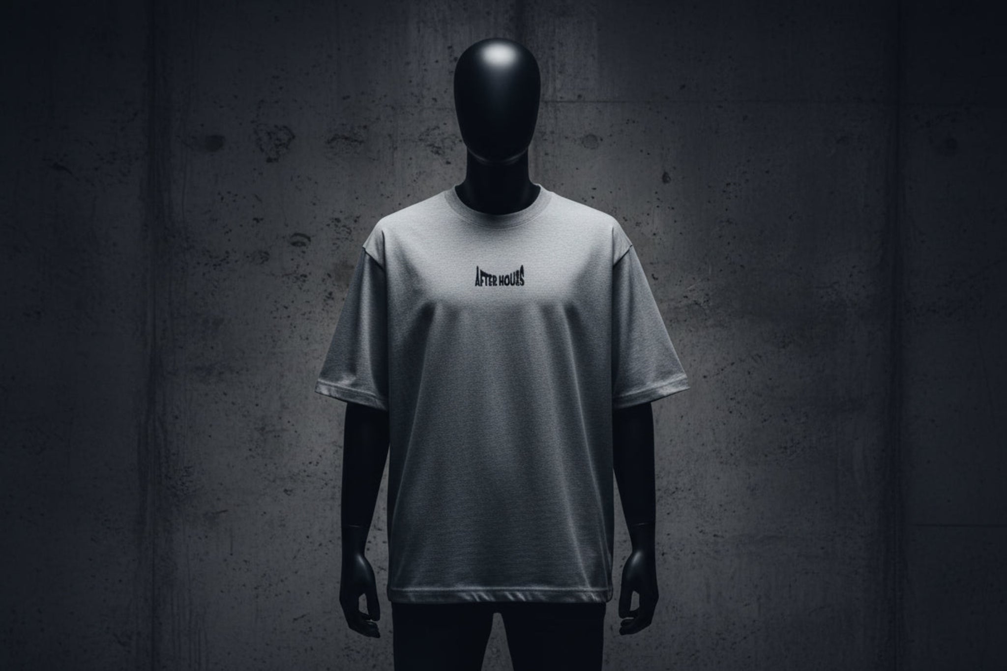 Grey t-shirt with a small black logo embroidered on a grey background