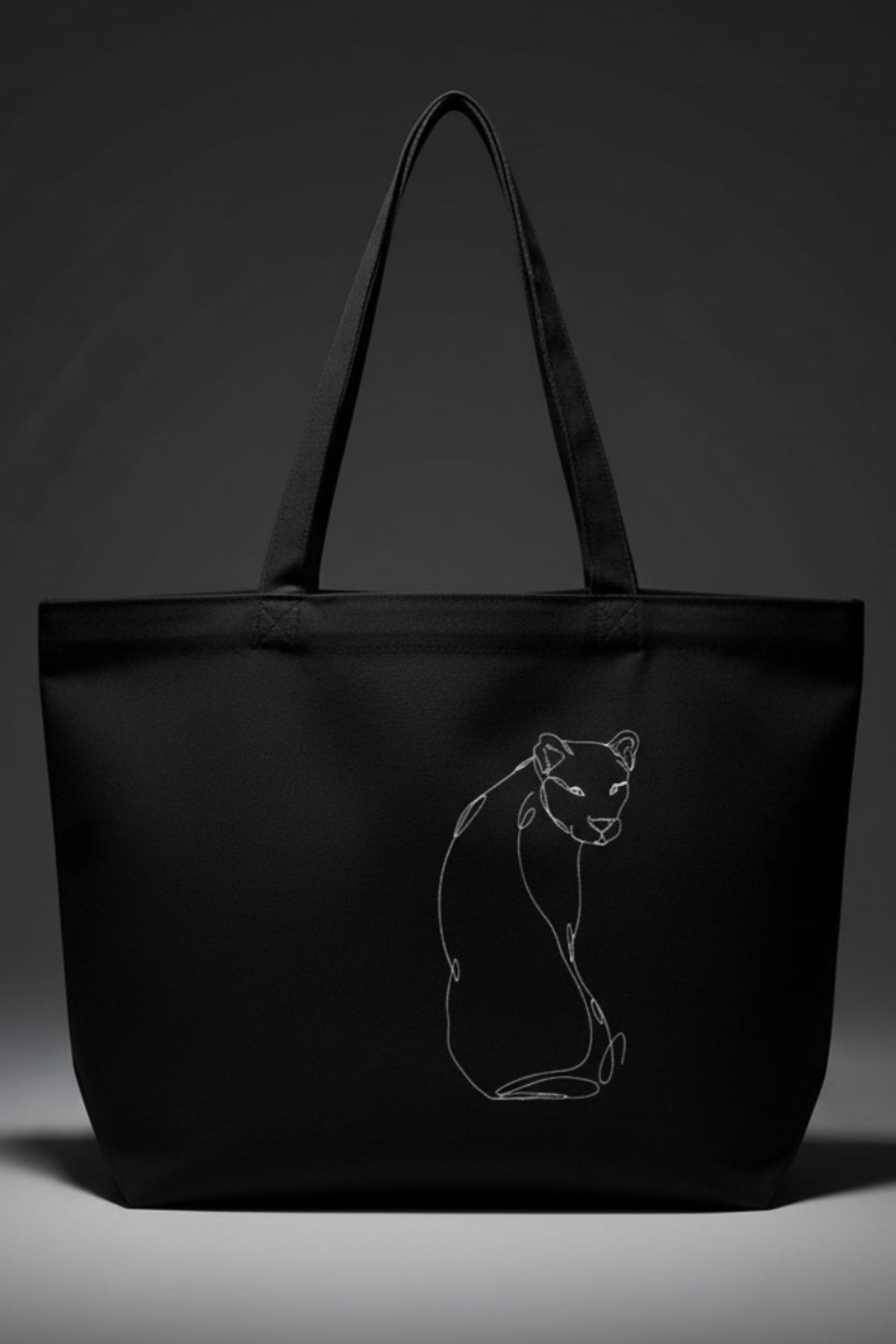 A black tote bag against a grey background