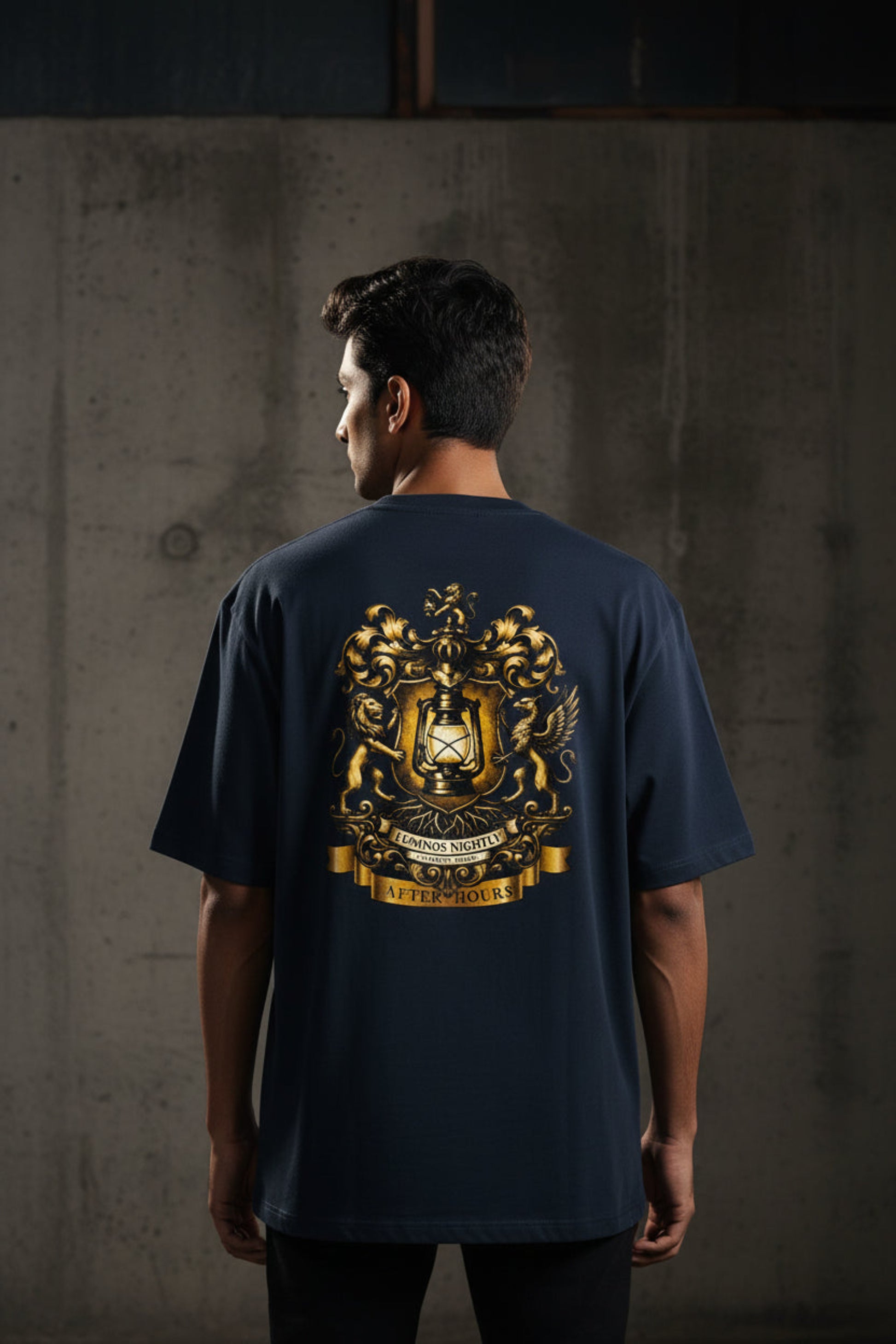 Navy blue t-shirt with gold After Hours Coat of Arms emblem on a grey background