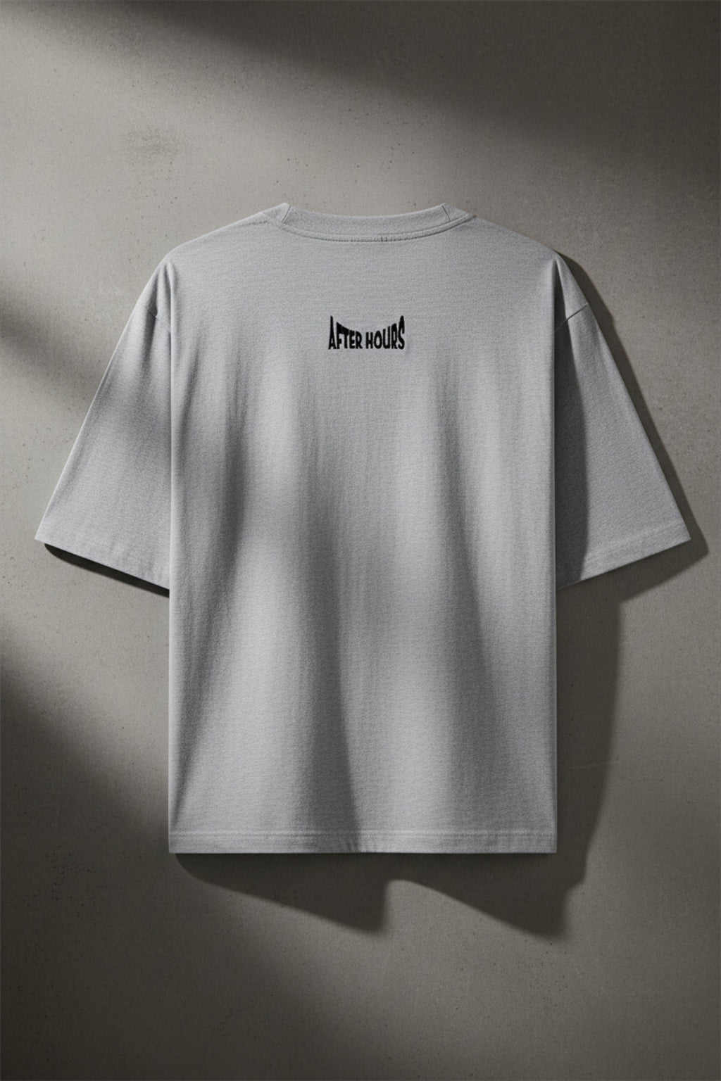 Grey t-shirt with 'After Hours' text embroidered on the back against a grey background