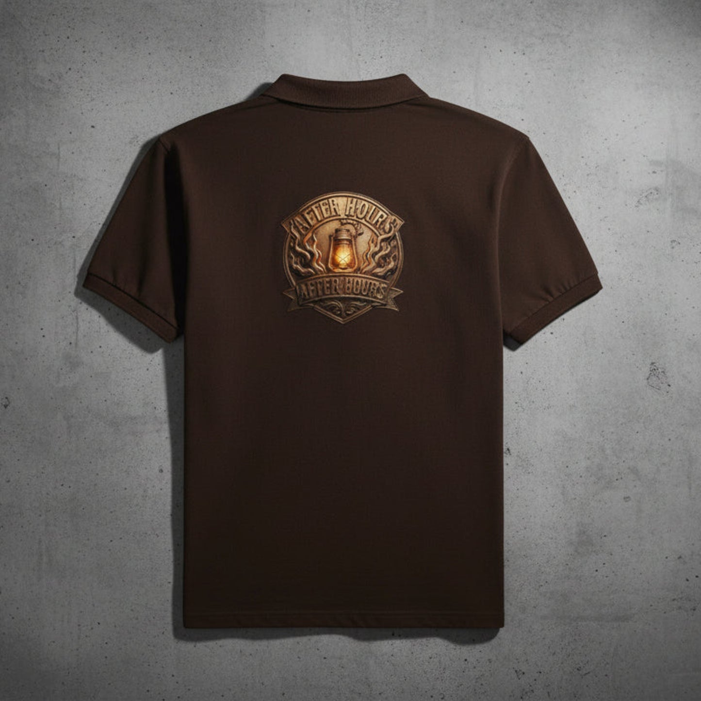 Brown t-shirt with a logo on the back against a grey textured wall backdrop