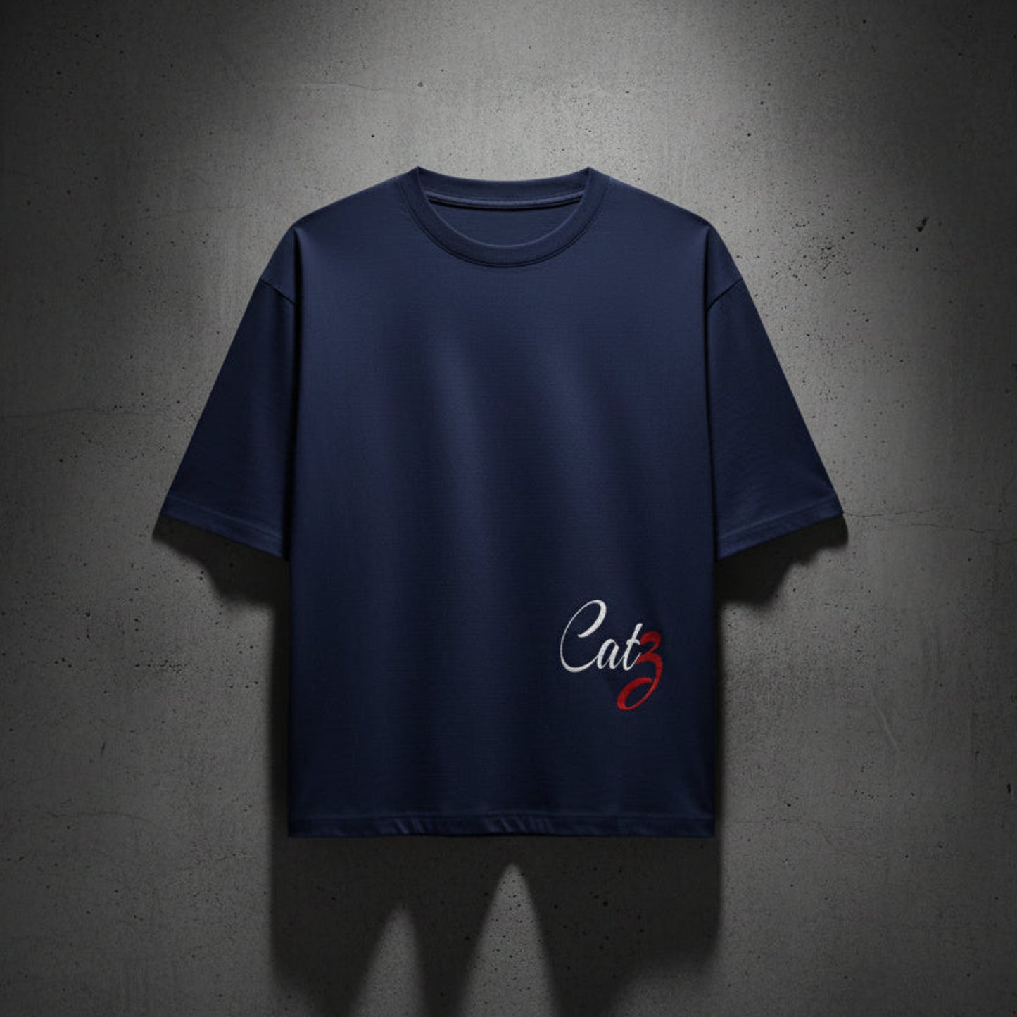 Royal blue t-shirt with a Catz writing on a textured grey wall background