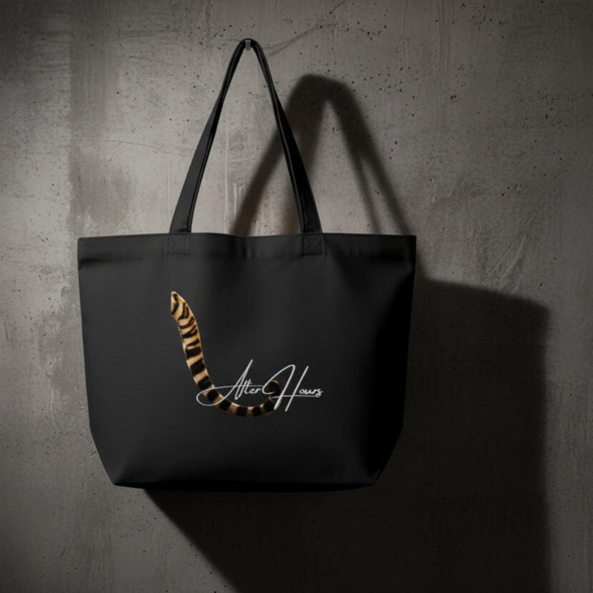 Black tote bag with a tiger stripe design and 'After Hours' text on a grey background