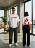 Two models in a modern loft-style room wearing white graphic t-shirts. The male model on the left shows the front of a white t-shirt with red text reading 'AFTER HOURS'.