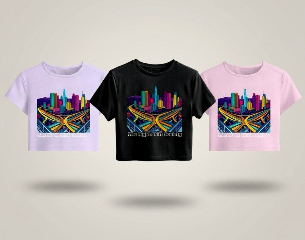 Three t-shirts with colourful cityscape designs on a light grey background