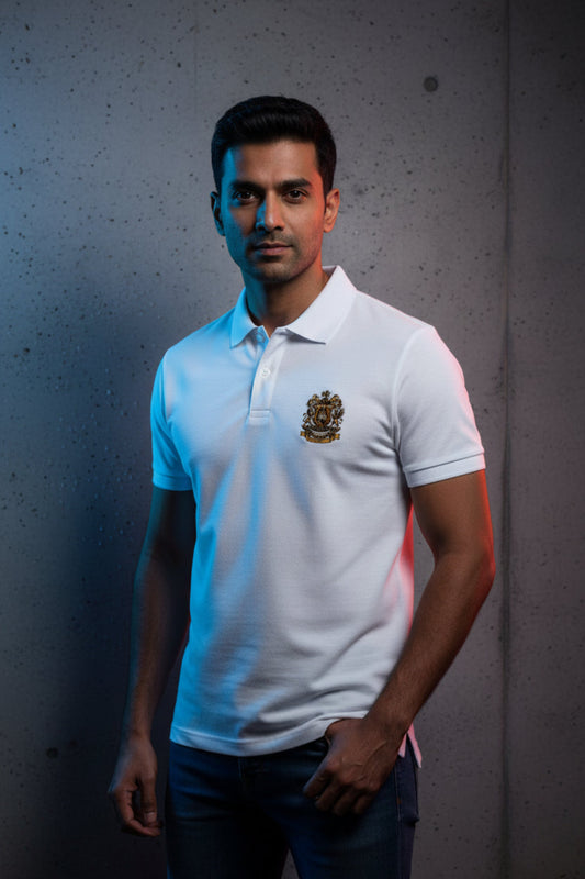 White polo shirt with a gold emblem on a grey textured wall background