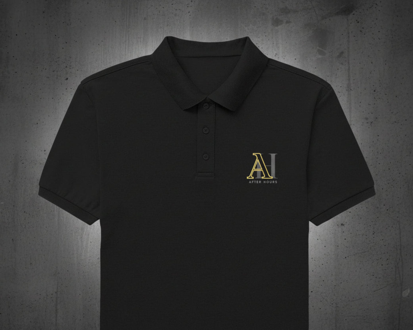 Black polo shirt with gold logo on a grey textured wall background
