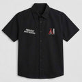 A black short-sleeve button-up shirt with 'PROUDLY ANTI-SOCIAL' printed in white on the right chest and a red and white 'AH' logo on the left chest, displayed on a light gray background.