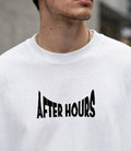 A close-up of a person wearing a white crewneck t-shirt with the words 'AFTER HOURS' printed in a stylized black font across the chest.