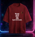 A dark red t-shirt with white printed text reading 'No one cared who I was until I put on a mask.' and a small 'AH' graphic in orange and black on the left chest, displayed against a dark background with neon blue and pink lights.