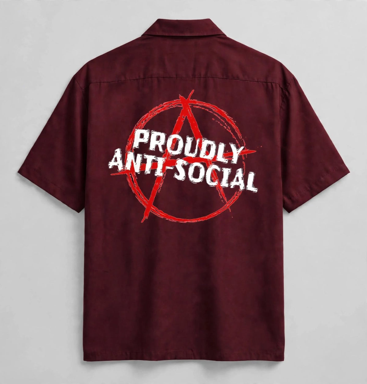 A short-sleeve button-up shirt shown from the back, featuring a large red anarchist symbol and the words 'PROUDLY ANTI-SOCIAL' printed in white across the center.