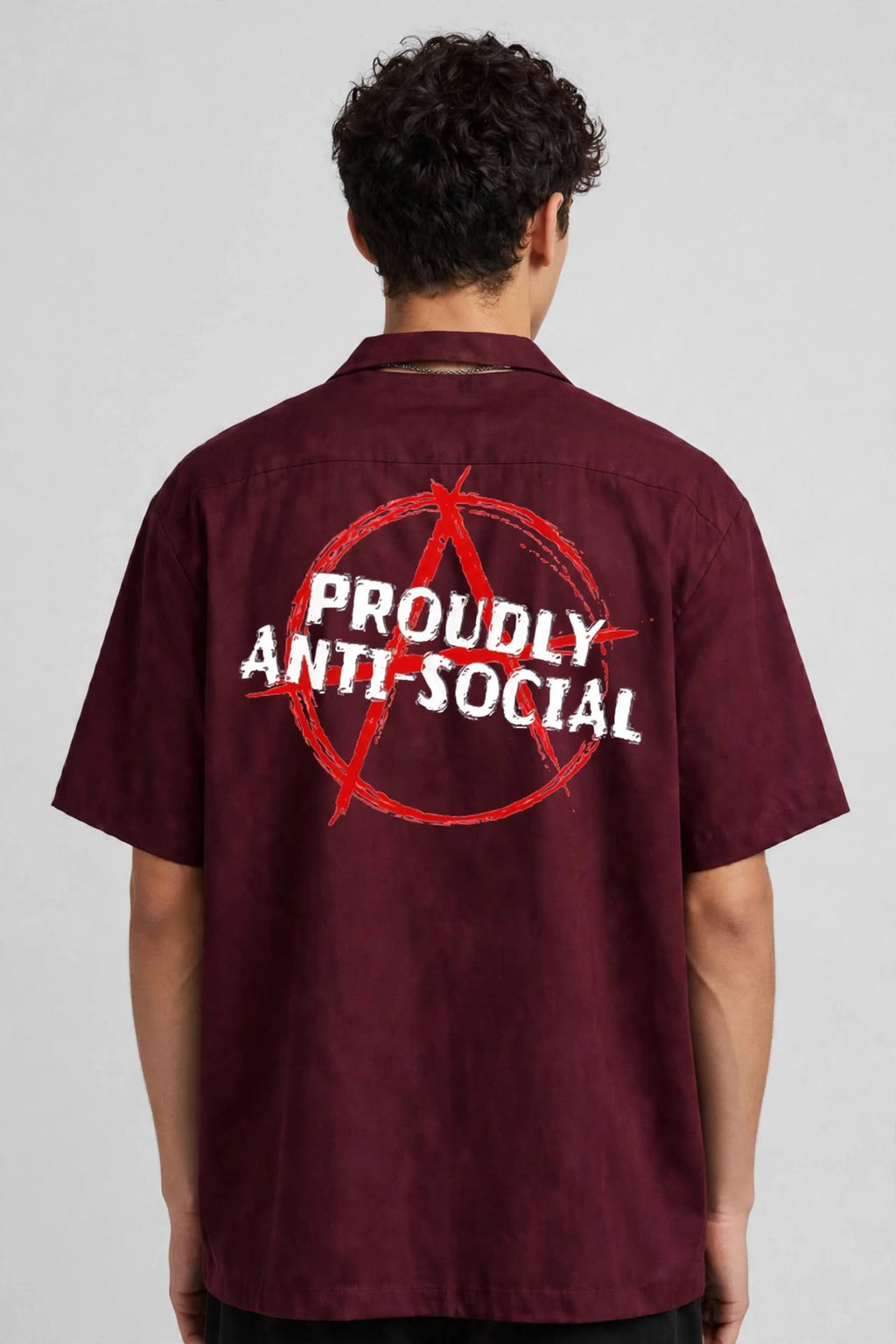 A man viewed from behind wearing a short-sleeve maroon button-up shirt with a large back graphic featuring a red anarchy symbol and the words 'PROUDLY ANTI-SOCIAL' in white.