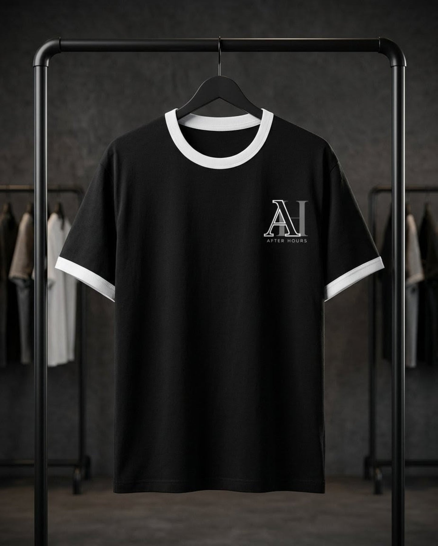 Black t-shirt with white trim and After Hours logo on a rack against a dark background