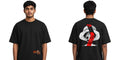 A man modeling a black short-sleeve t-shirt, showing both the front and back views. The front features a small orange graphic on the lower left, while the back displays a large graphic of a straw-hat character with red and black details.